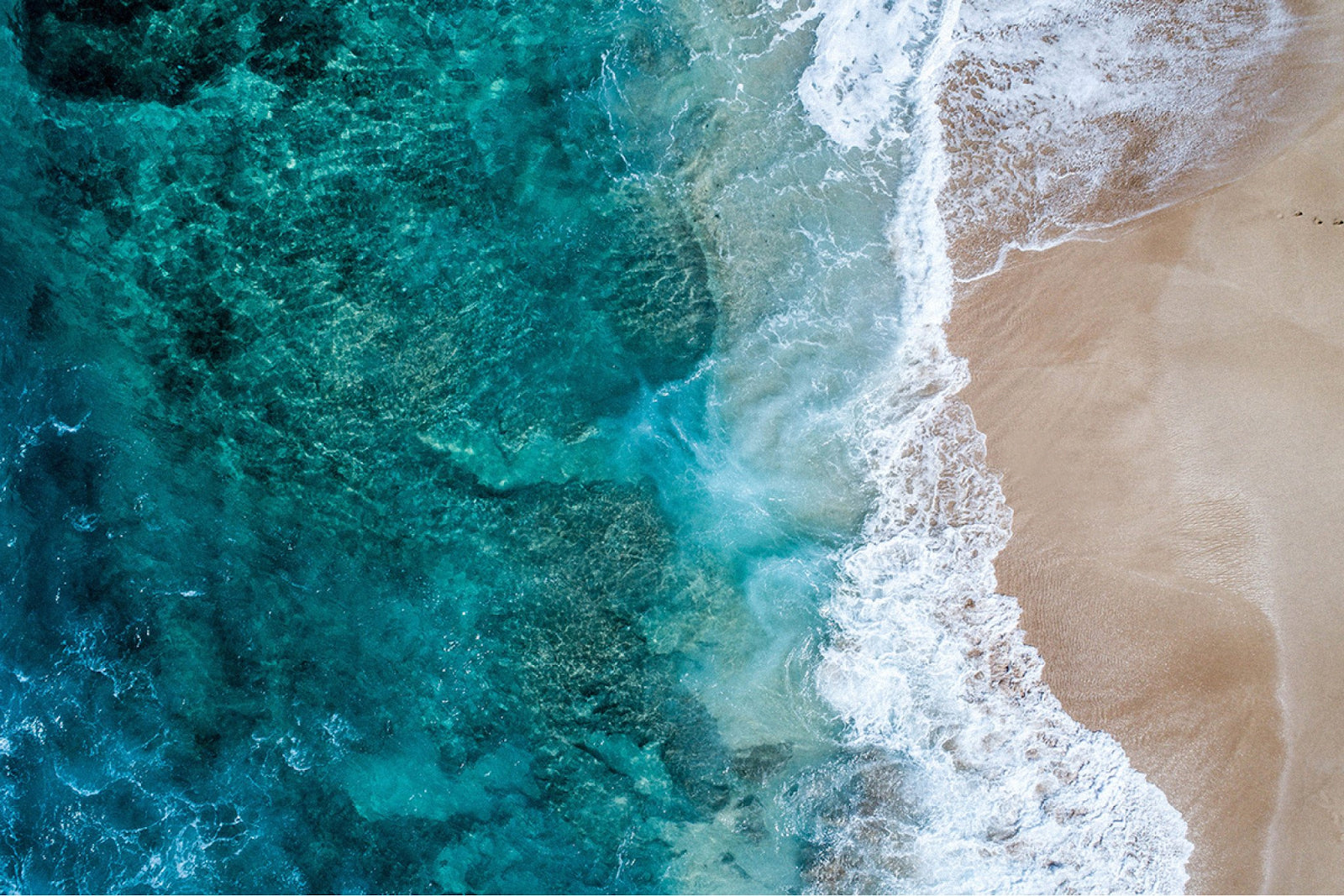 aerial view of waves and beach sand